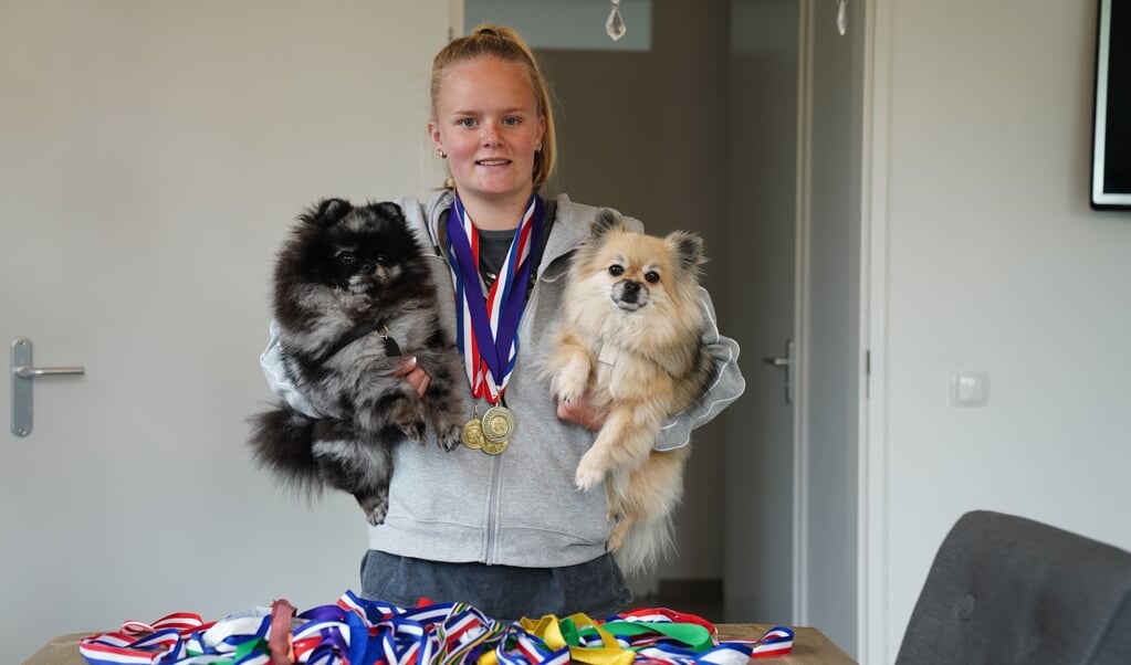 Nikki met medailles en de honden van de familie. 