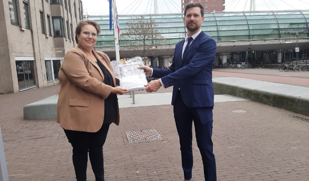 <p>De handtekeningen worden overhandigd aan wethouder Bos. </p>