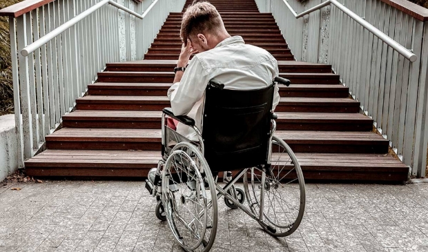 Gefrustreerde rolstoelgebruiker voor een trap