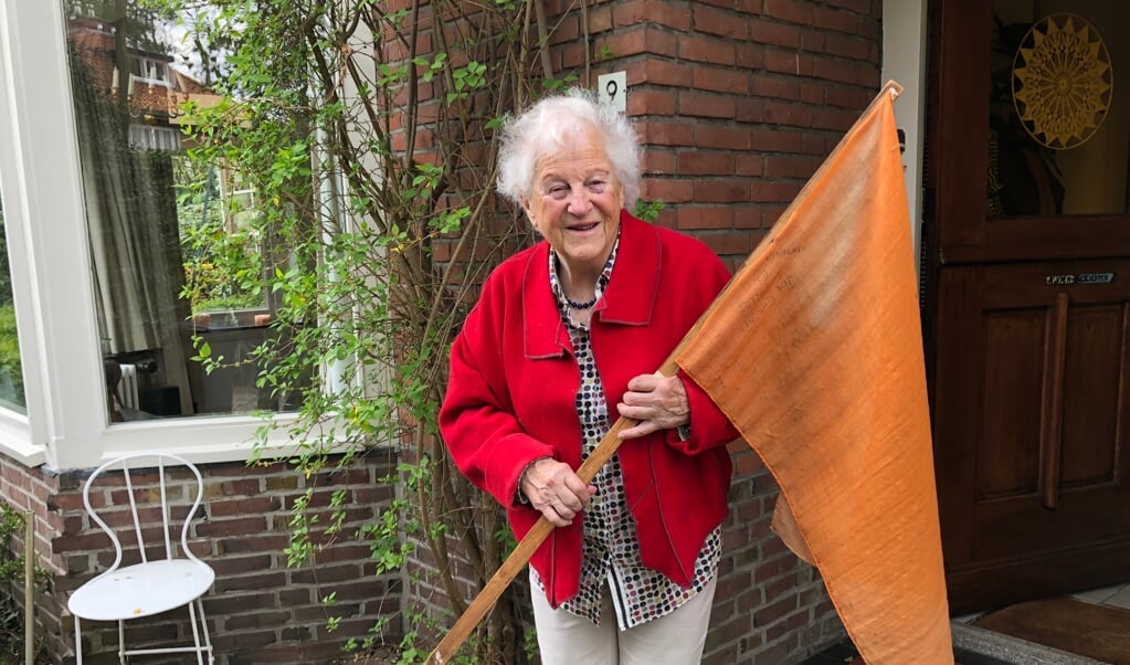 De 87-jarig Loes Kuiper met de vlag waar ze de Canadese bevrijders mee toezwaaide.