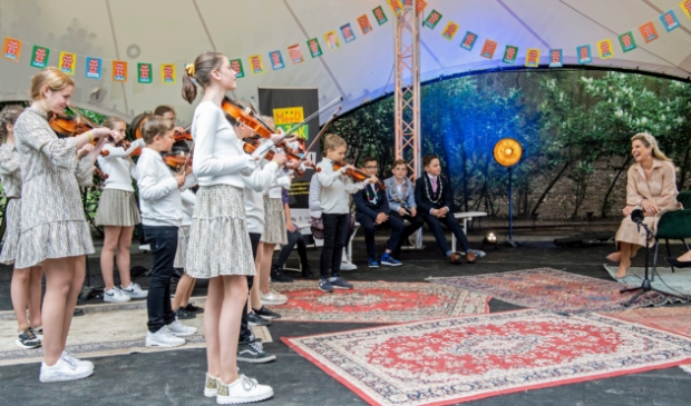 <p>Koningin Máxima luistert aandachtig naar de kinderen.</p>