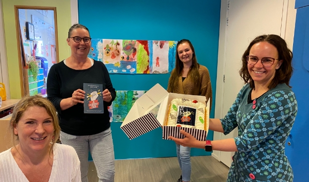 Maike Douglas-Westland reikt eerste exemplaar De gelukkige leraar uit aan leerkrachten OBS Piet de Springer