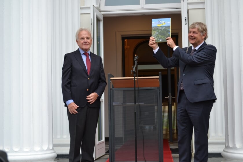 Burgemeester Roest is trots op het overhandigde boek uit handen van Wim Alferink (voorzitter 'Ons Bloemendaal'). 