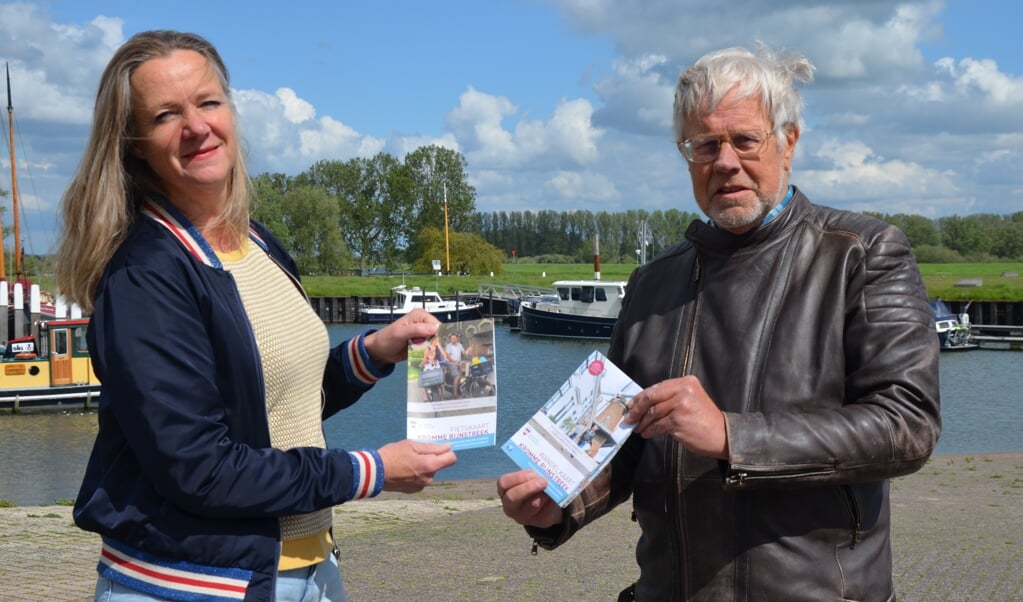 Coos van den Hoek neemt in de Wijkse haven de fiets- en wandelkaart in ontvangst