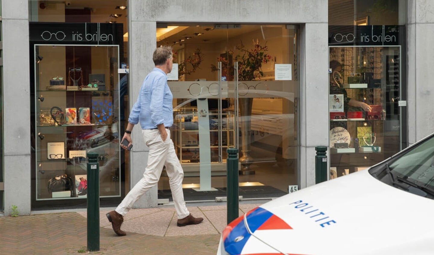 Burgemeester Mark Röell arriveert bij de overvallen winkel in de Laanstraat. 