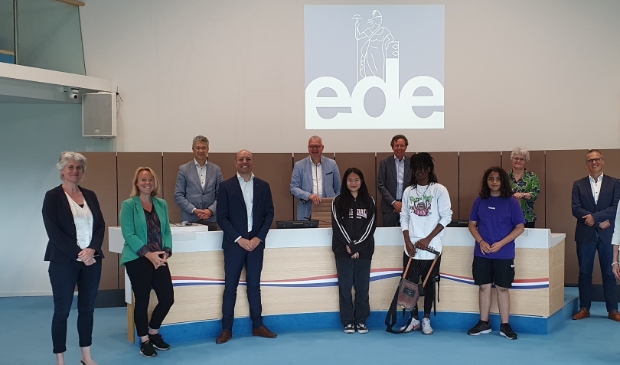 Achterste rij: wethouder Meijer van de gemeente Ede en de bestuurders VO-scholen. Voorste rij: Nicole Weigergangs (gemeente Ede), Willienda Dam, Alexander van Horssen, leerlingen en Wilhelmien Baalbaki, allen ISK