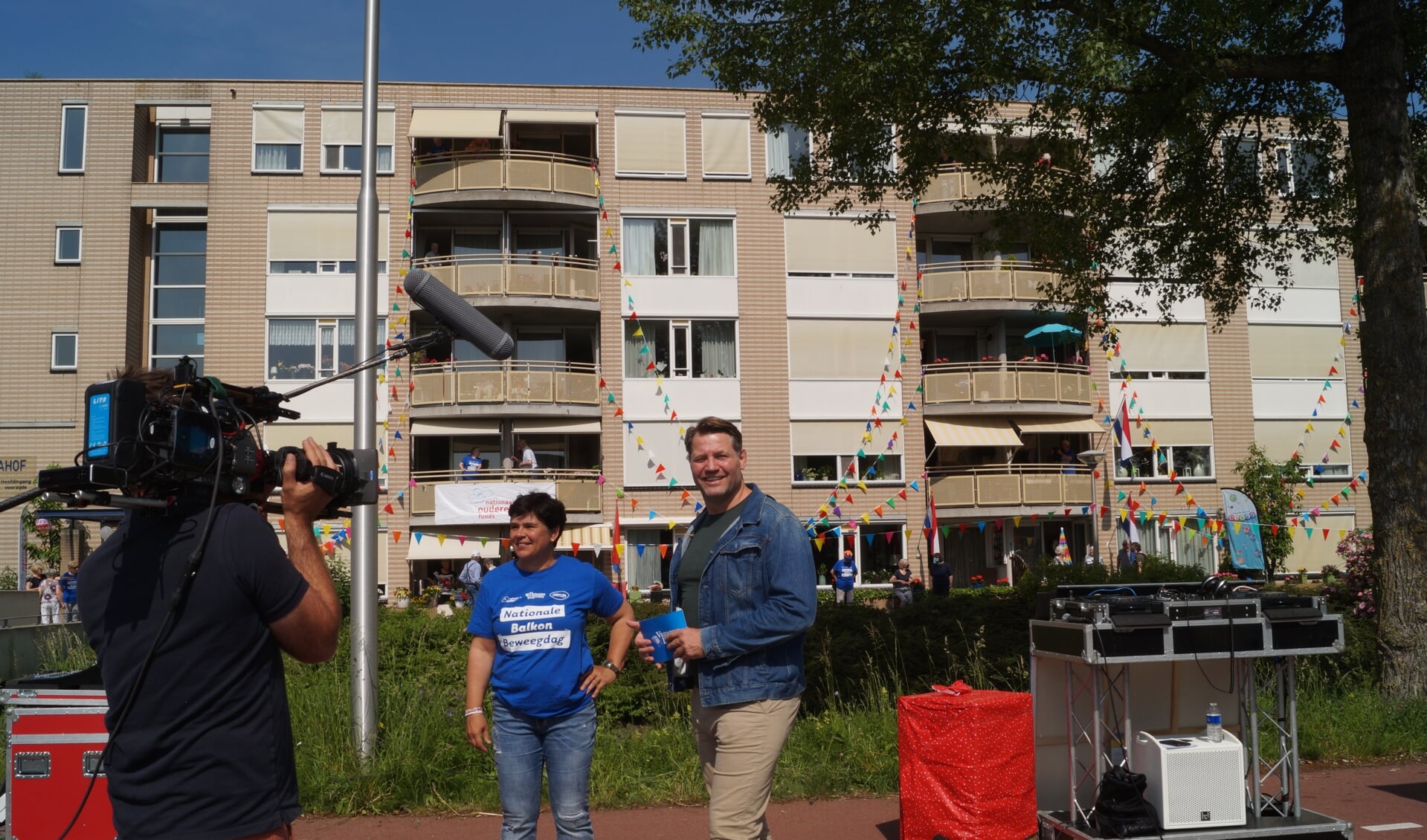 Mieke Regelink met DJ Dennis van der Geest bij de feestelijke editie van het balkonbewegen bij de Dignahoeve.