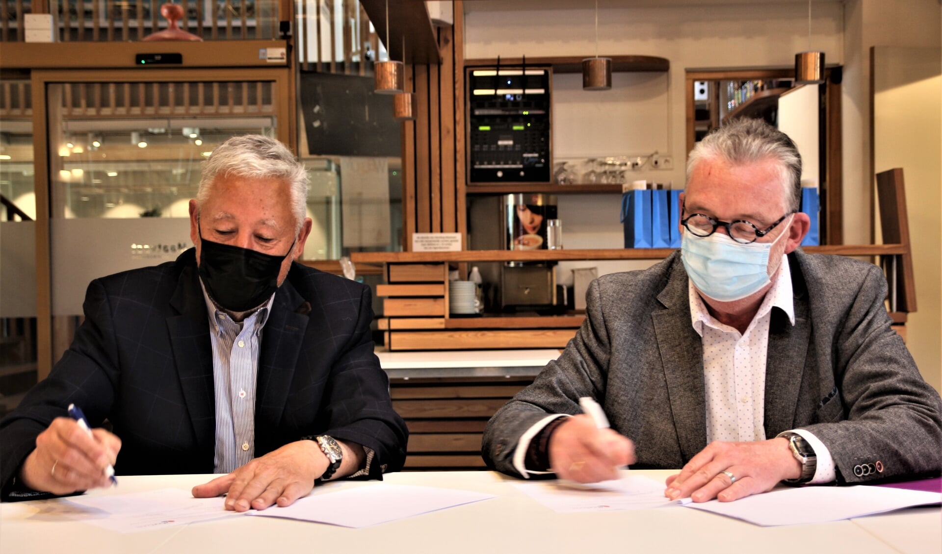 Hans de Bats (l) en Maarten Askamp  voorzien de overeenkomst van hun handtekening.