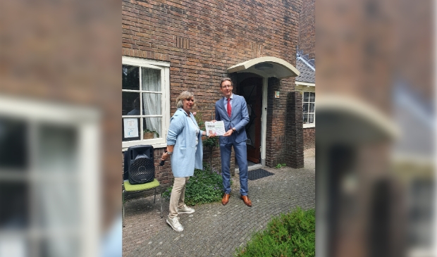 <p>Burgemeester Tjapko Poppens neemt het eerste exemplaar in ontvangst.</p>