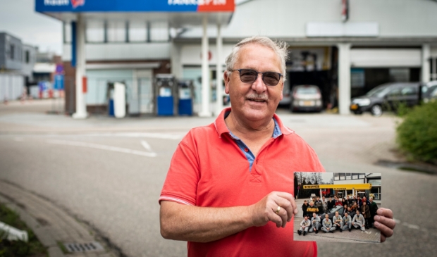 <p>Piet de Ruijter met de teamfoto van 1992, op de plek waar vroeger de Schipper-pomp en garage zaten.</p>