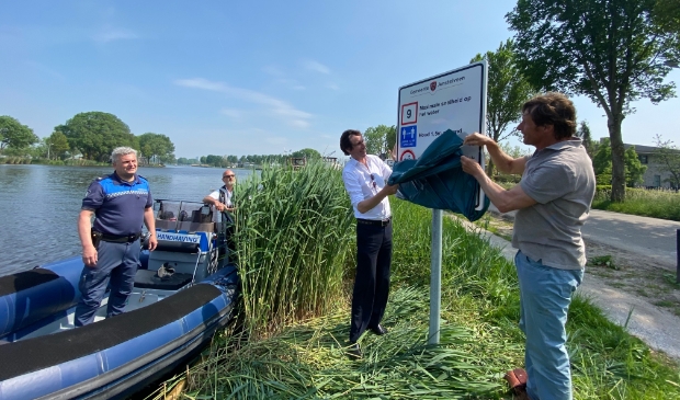 <p>Wethouder Herbert Raat onthult een bord met vaarregels die gelden op de Amstel in het bijzijn van Handhaving en Peter Hesp, voorzitter van de Vereniging Amstel Oever. </p>