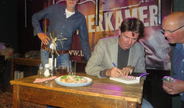 Twan Huys signeert zijn boek de Clintons in de Teerkamer.