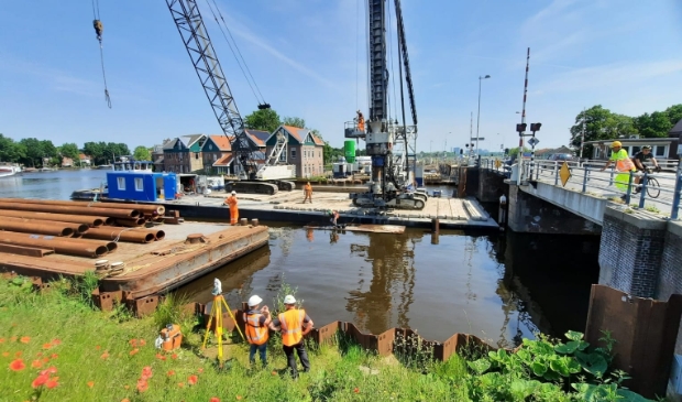 <p>De buispalen liggen op het voorste ponton klaar om opgehesen te worden door de hulpstelling of het andere ponton.</p>