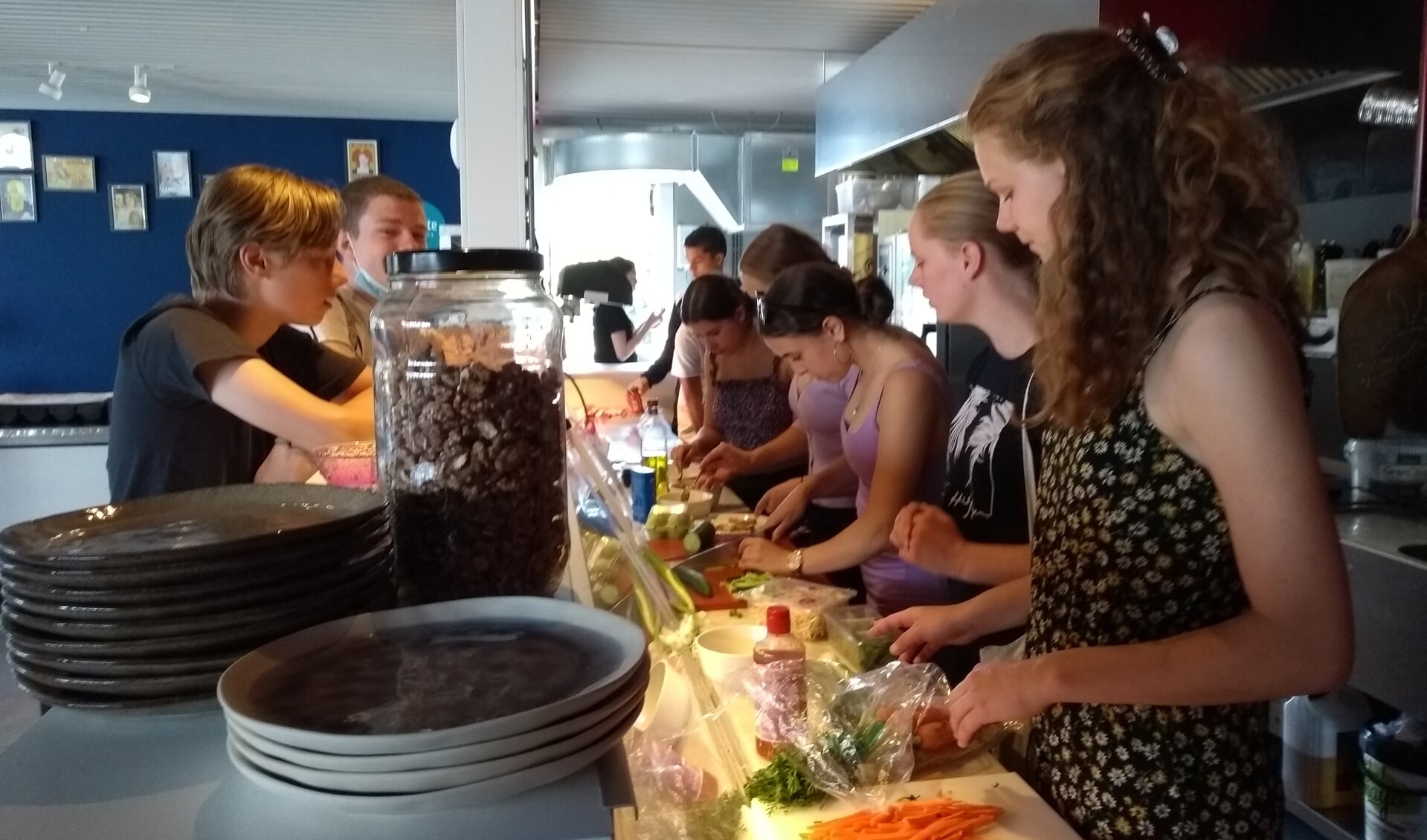 Leerlingen zijn in  de keuken druk bezig om de laatste hand aan de gerechten te leggen. 