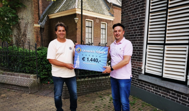 <p>Links Aalt van de Bunt penningmeester van de stichting De Mooiste Verlicht en rechts Gerwin Poolen namens de Lions Nijkerk.</p>
