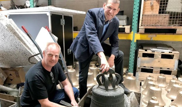 Joep van Brussel (links) en koster Anton van der Vlist met de klok uit Tull en 't Waal.