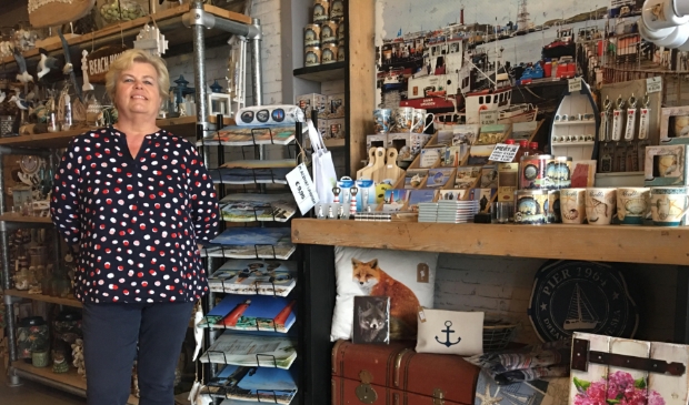 <p>Adrie Klinge in haar souvenirwinkel 'Groeten uit IJmuiden'.</p>