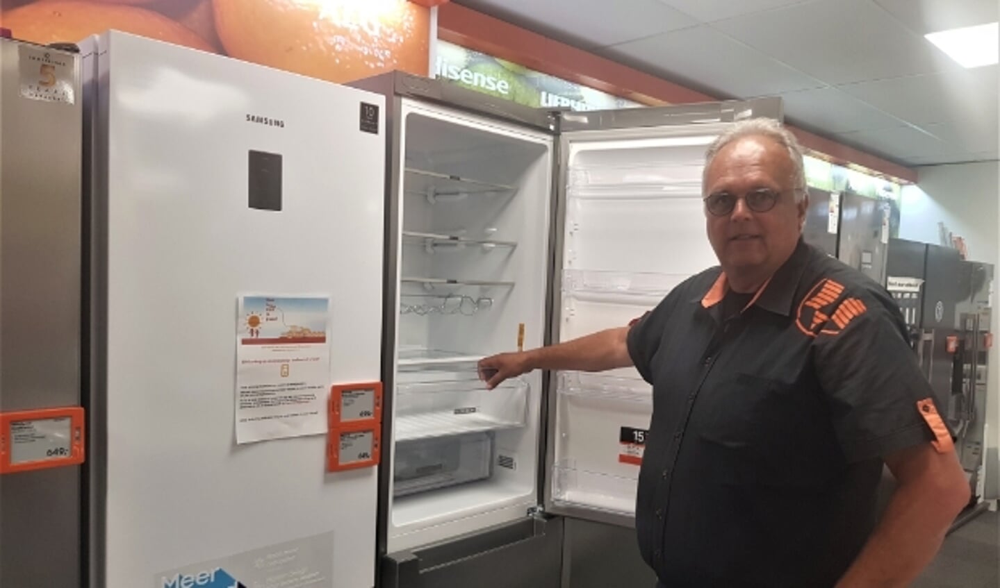 Herbert Boon toont een van de energiezuinige koelkasten die voor de kortingsactie in aanmerking komt. (foto: Kees Stap)