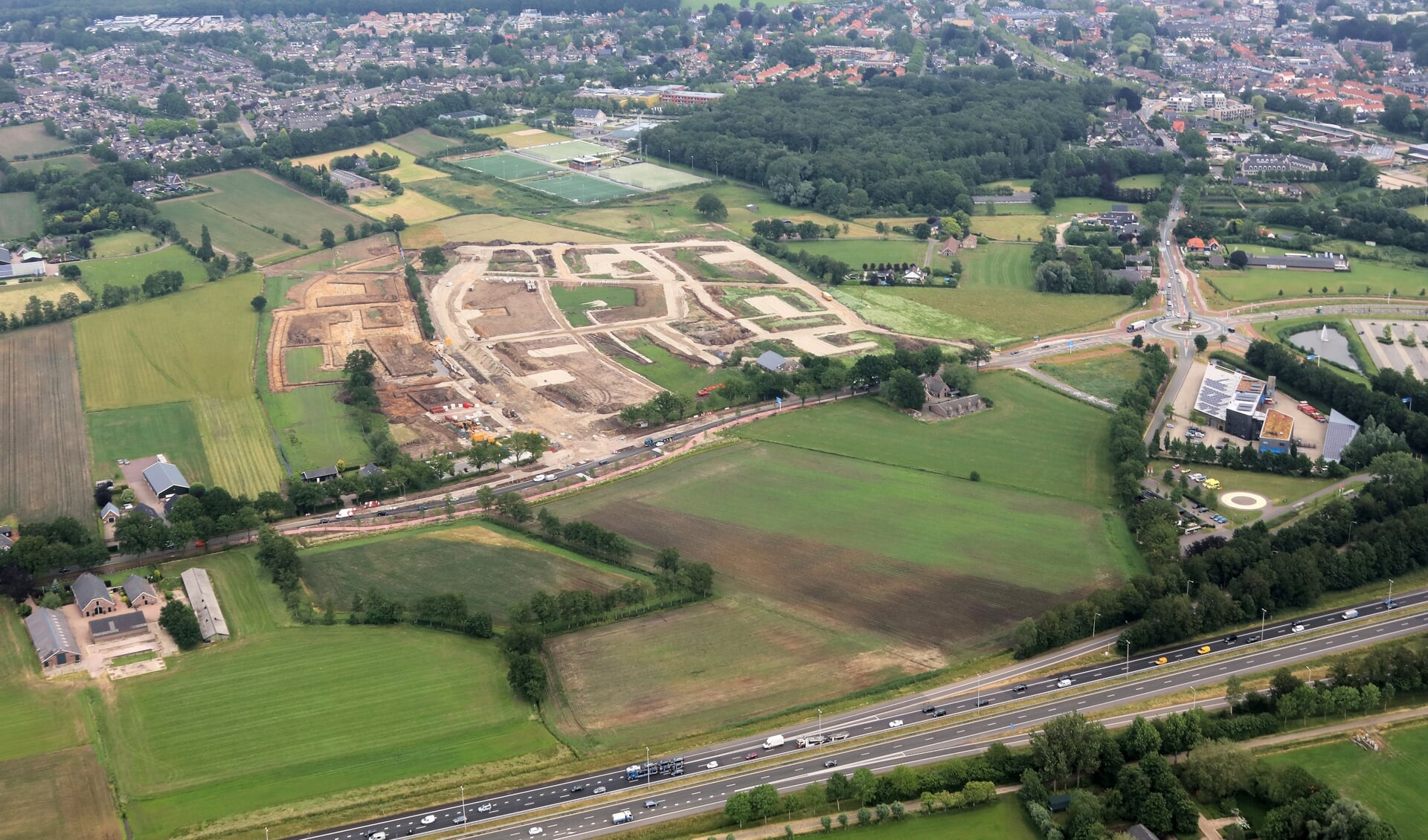 Luchtfoto van de plek langs de Nijkerkerweg waar het eerste deel van nieuwbouwwijk Bloemendal in Barneveld wordt gebouwd. Onderin snelweg A30.
