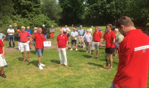 <p>Edwin Spee (witte sneakers) neemt de cheque in ontvangst onder grote belangstelling van leden DGC.</p>