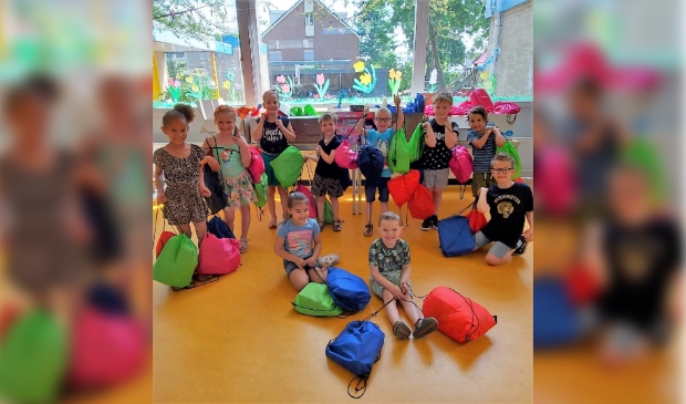 Leerlingen Koepelschool met een aantal gevulde rugtasjes.