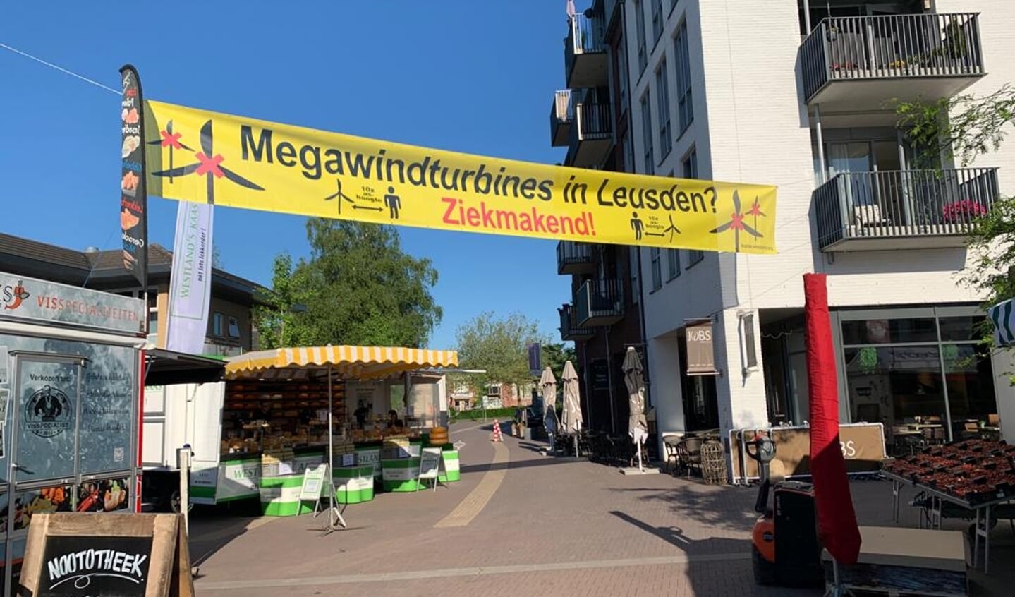De actiegroep Windalarm voert actie tegen windmolens in het buitengebied met een spandoek in winkelcentrum De Biezenkamp.