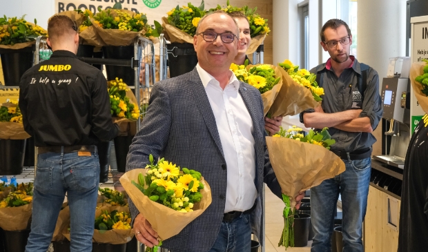 <p>Heropening Jumbo Hofman Hoofddorp, eigenaar Jack Hofman deelt bloemen uit aan snelle klanten.</p>