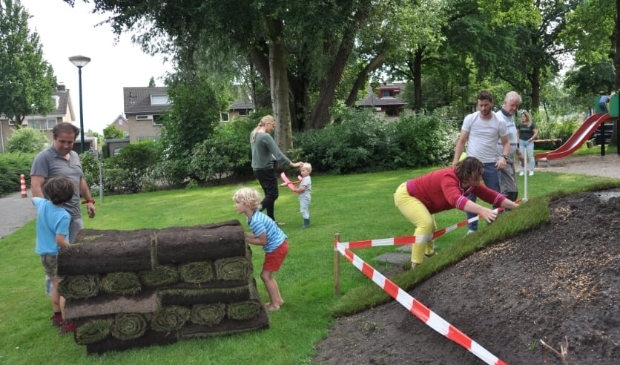 <p>Buurtbewoners, groot en klein, werken samen aan hun natuurspeeltuin (in het witte shirt: Eric Maathuis)</p>