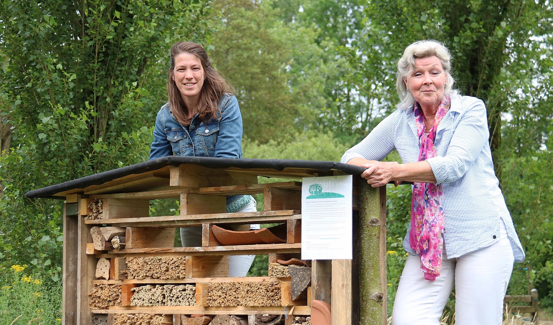 Lize Haarman (l) en Ineke de Lange bij het nieuwe insectenhotel in het parkje aan de Meerkoet.