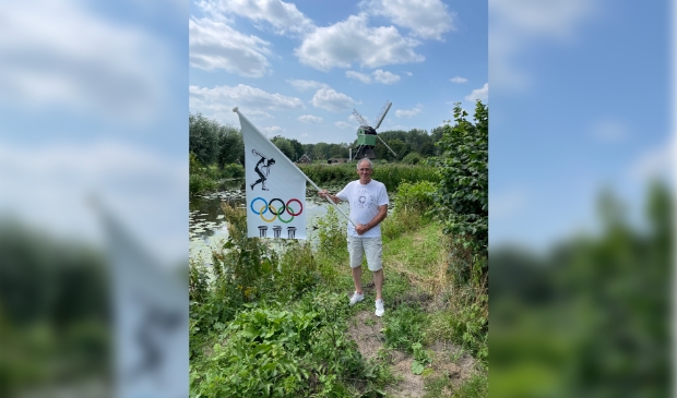 <p>Cees met zijn unieke Olympische vlag, liefst was hij op de atletiekbaan op de foto gegaan</p>