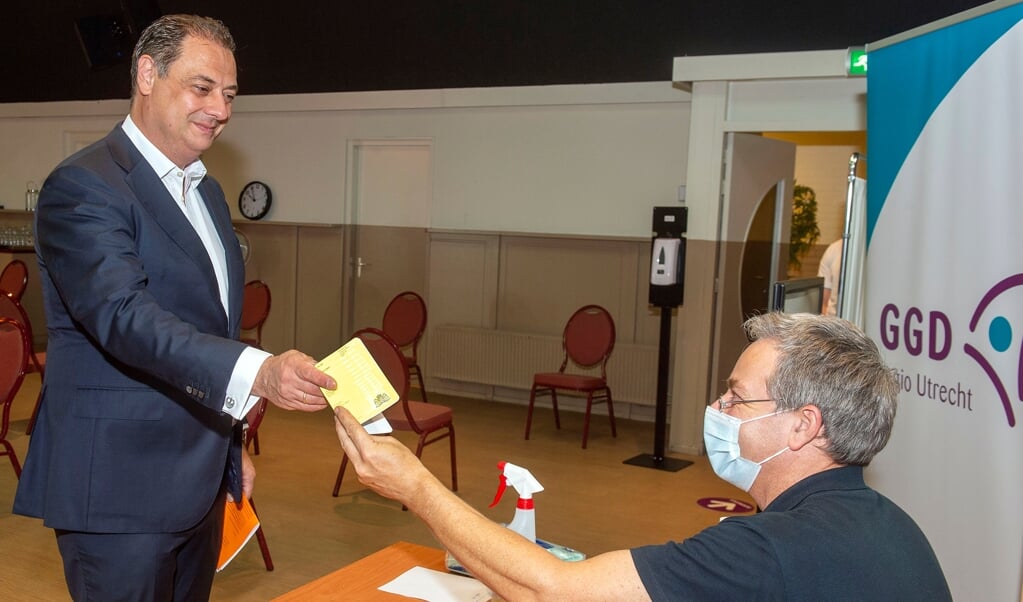 Burgemeester Bouwmeester krijgt het gele vaccinatieboekje terug, waarin nu ook de Covid 19-vaccinaties zijn opgenomen. 