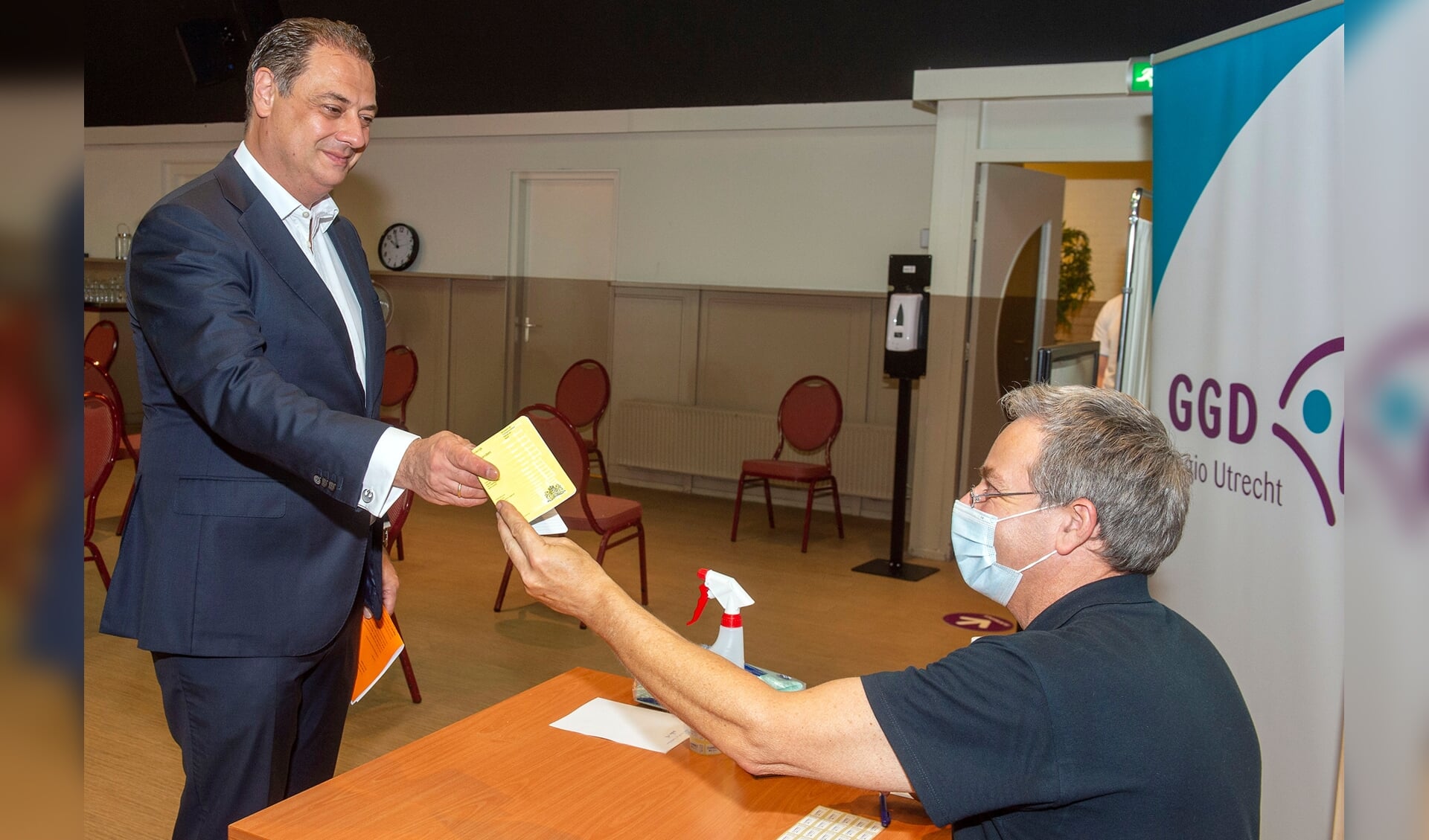 Burgemeester Bouwmeester krijgt het gele vaccinatieboekje terug, waarin nu ook de Covid 19-vaccinaties zijn opgenomen. 