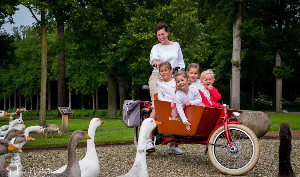 Joanne Baan en haar vier dochters zijn verknocht aan hun rode bakfiets van Het Fietsenhuis.