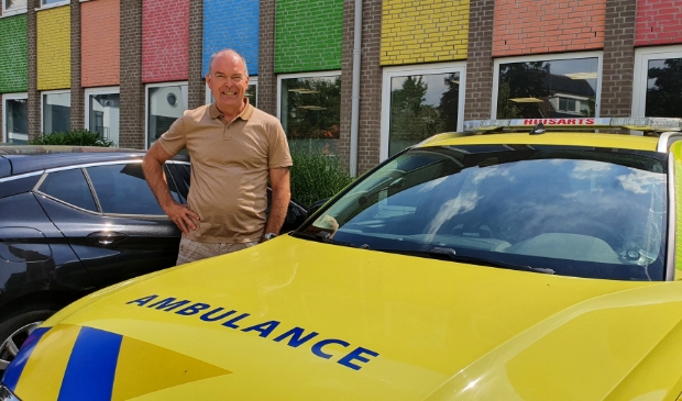 <p>Huisarts Marcel Ebbing bij de ambulance waarmee hij met een ambulancechauffeur snel bij een patient komt</p>