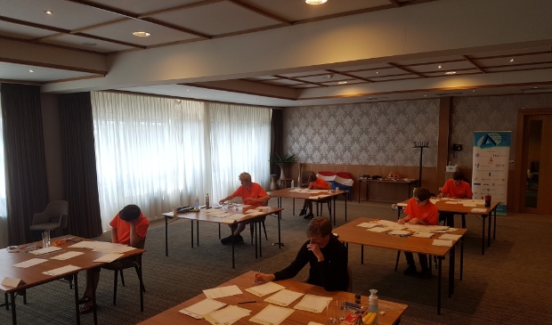 Het Nederlandse team op de eerste wedstrijddag. Bij het raam van voor naar achter: Kees, Hylke Jelle. Bij banner van voor naar achter: Thian, Casper, Kevin.