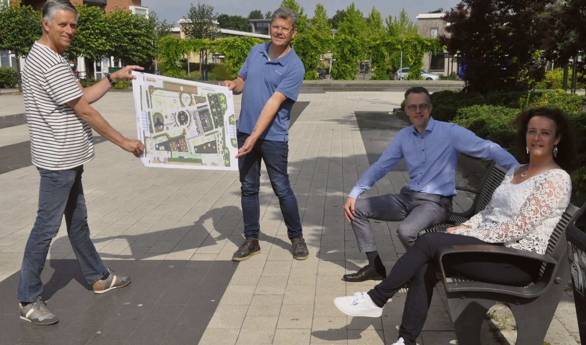 Willem Massier en Gerald Kersjes (links) van het wijkplatform, overhandigen de schets aan wethouder Hans van Daalen. Uiterst rechts gebiedsregisseur Lysette Lubbers.