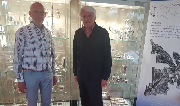 <p>Bestuursleden van de Zilver-Kamer Pierre Rhoen (links) en Rudi Boekhoven voor twee van de vitrines in hotel Oud London. </p>