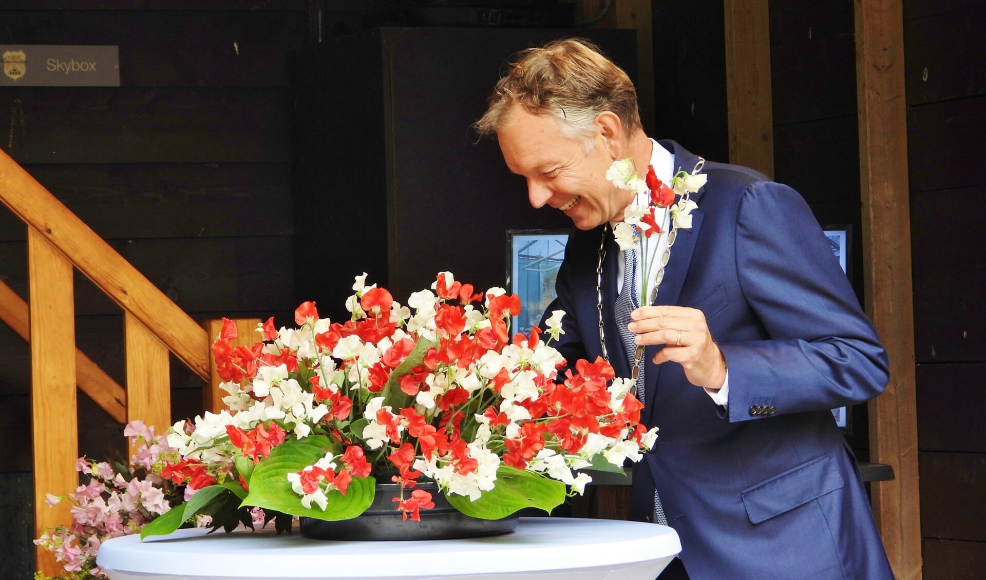 Burgemeester Röell voltooide een lathyrusbloemstuk met rood witte kleuren. 