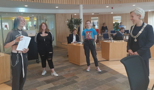 <p>Max, Lieke en Lilly overhandigen de petitie aan burgemeester Iris Meerts</p>