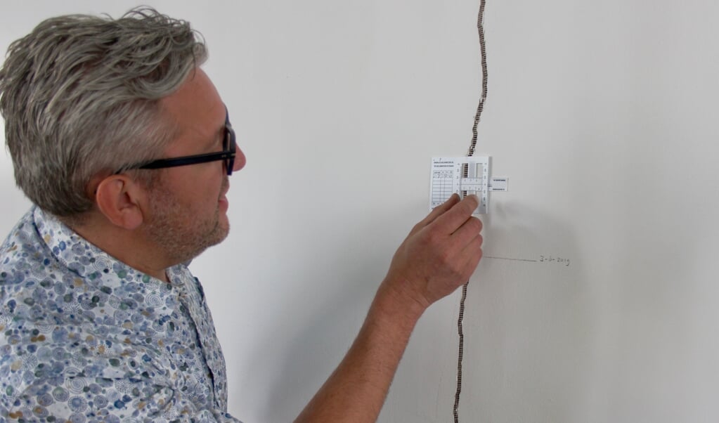 Kerkenraad-voorzitter Johan Oldenhage inspecteert een scheur in de muur van de Witte Kerk