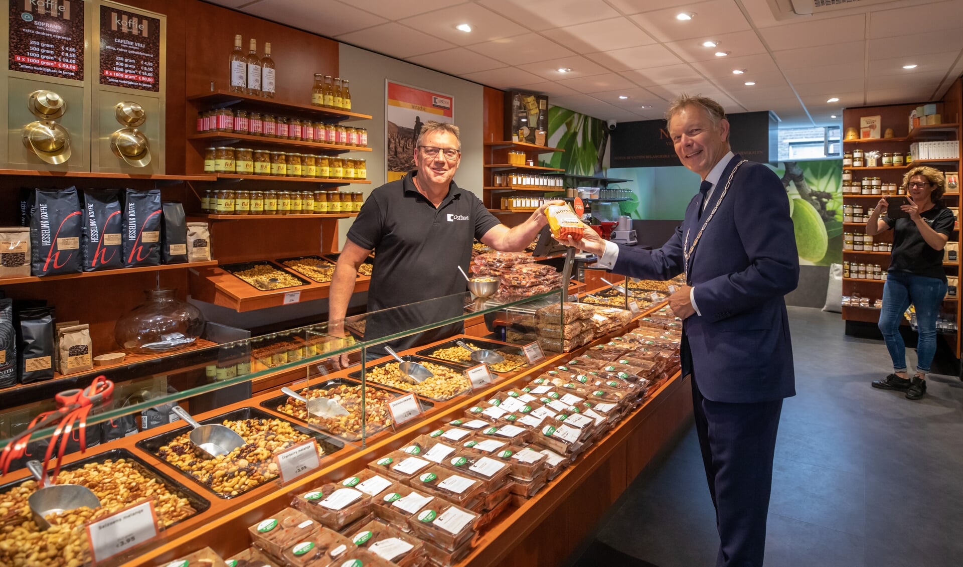 Burgemeester Mark Röell en Roel Kloppenburg in de vernieuwde notenwinkel. 