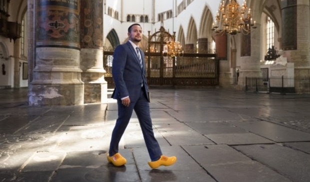 <p>Mounir Samuel op boerenklompen in een kerk</p>