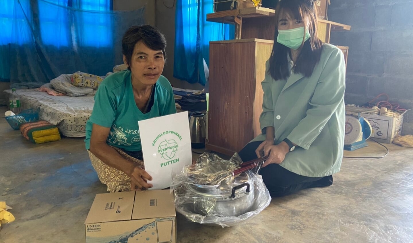 Lokale medewerkster Siam Care Foundation deelt een voedselpakket en kookpannen uit het laatste gebeurt daar de huidige pannen totaal versleten zijn .