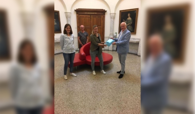 Monique Verloop van Jayda CC reikt het sociaal jaarverslag uit aan wethouder Fluitman van de gemeente Zeist
