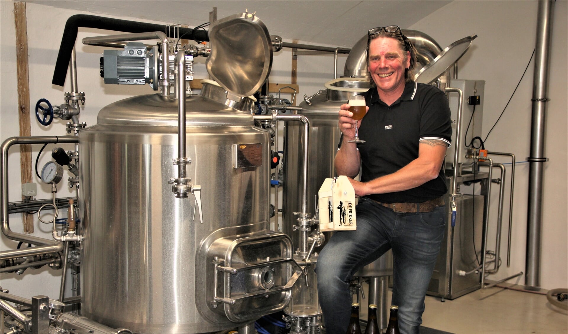 Erwin Groot met bier en bitter in de brouwerij.