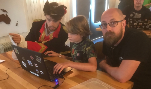 <p>Generaal Kraijenhof assisteert de kinderen bij het kraken van de code voor de UNESCO schatkist</p>