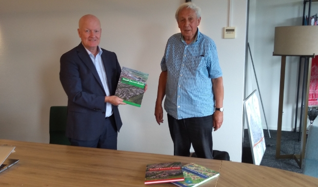 <p>Burgemeester Ruud van Bennekom nam het boek in ontvangst van schrijver Jan Kleinpenning.</p>