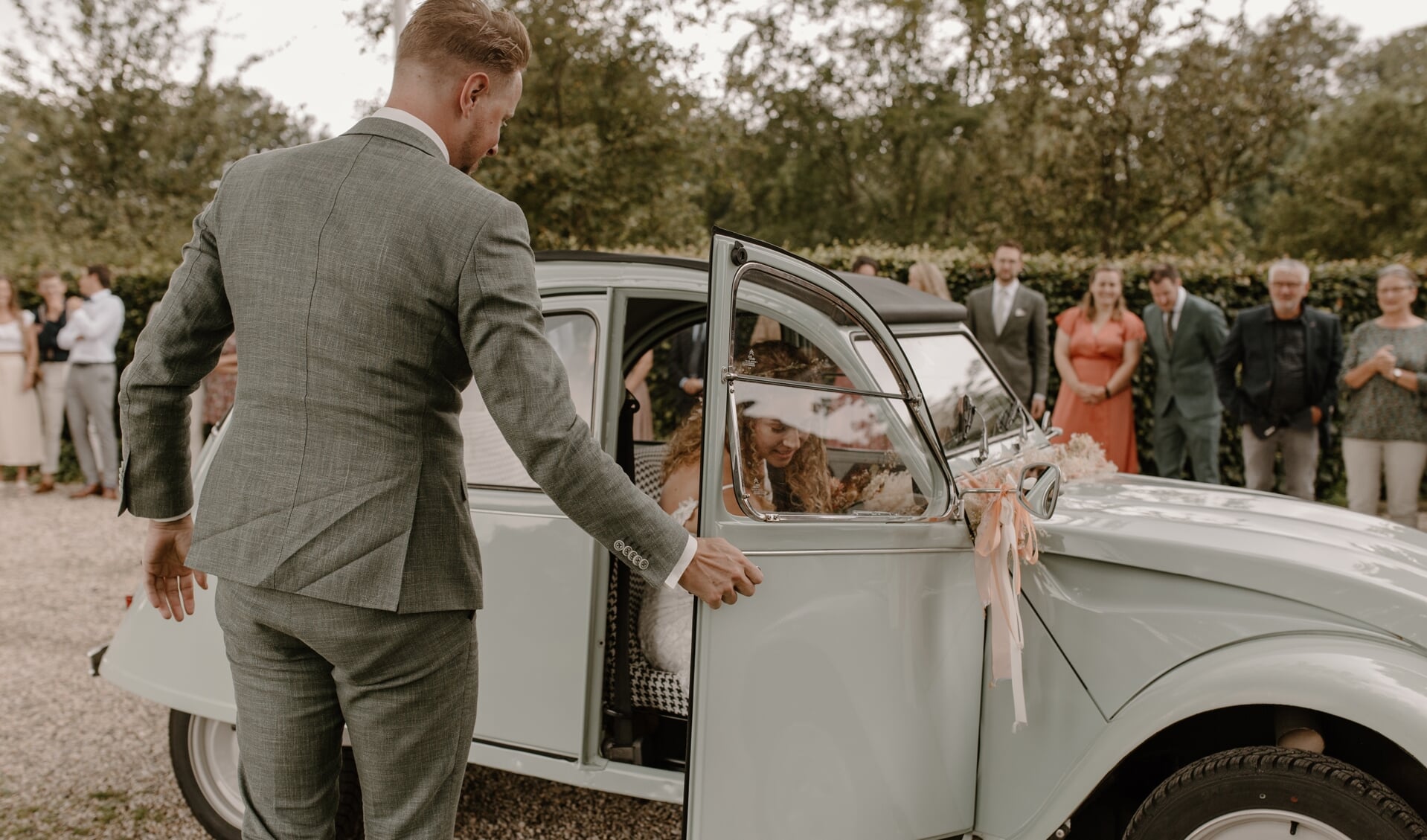 Lyn Brandsma wordt door bruidegom Frank Wallet in de auto geholpen.