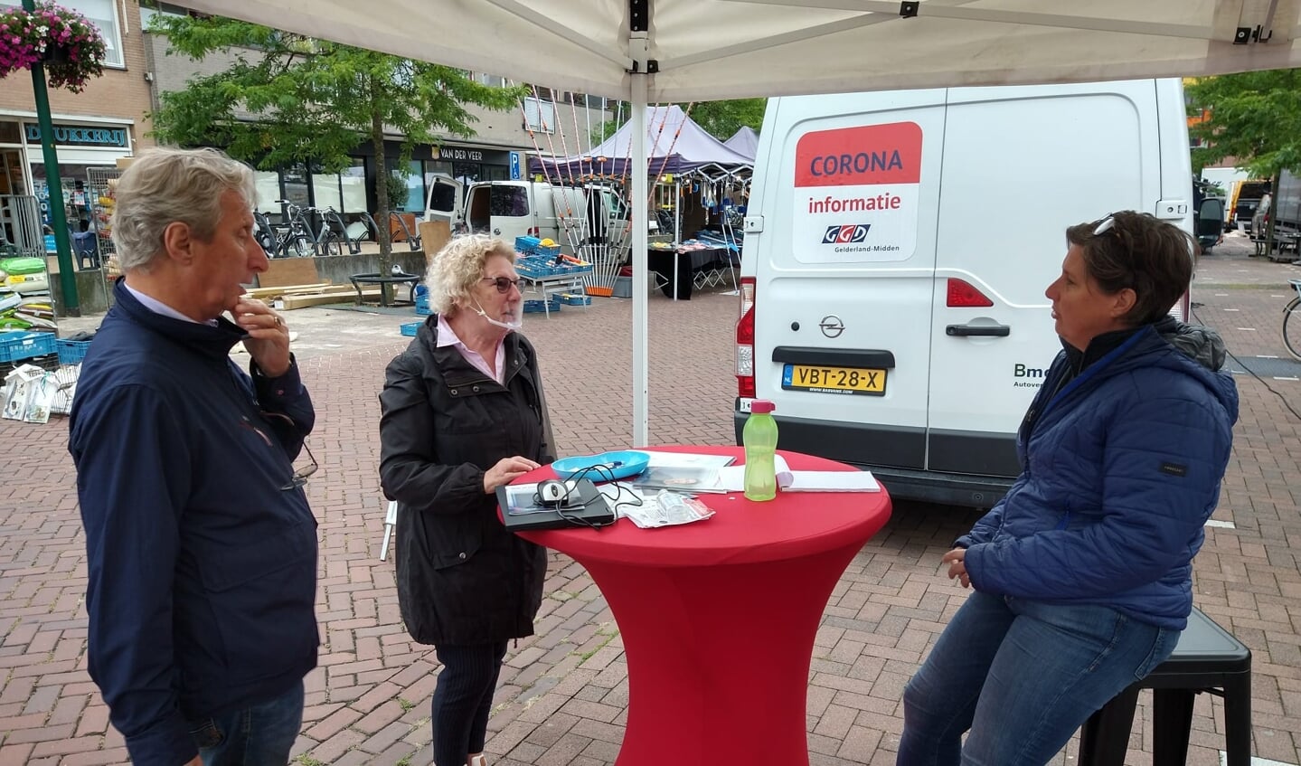 Marijke en Tom Verharen in gesprek met Sandra van de GGD, bij de corona-infobus.