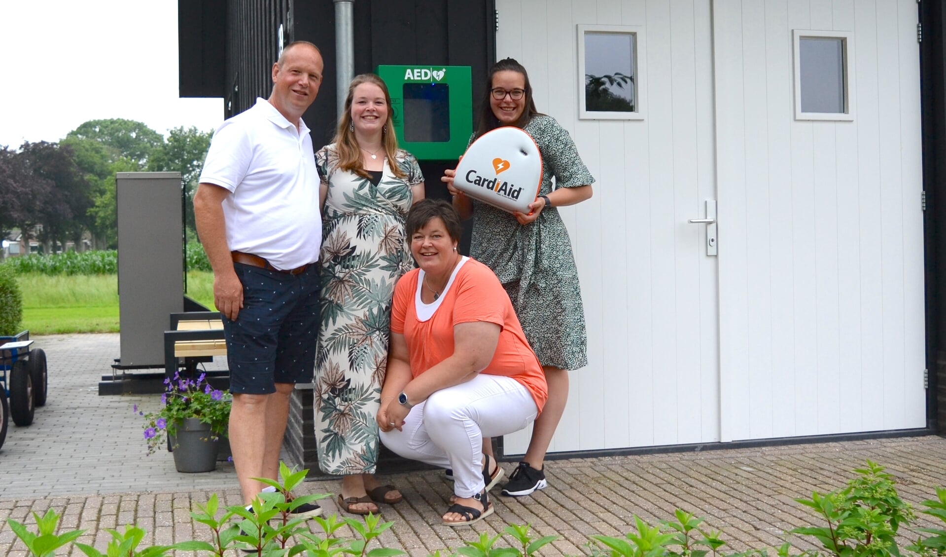 Mario en Rijanne Bos en hun dochters zijn blij met de plaatsing van de AED aan hun gevel.